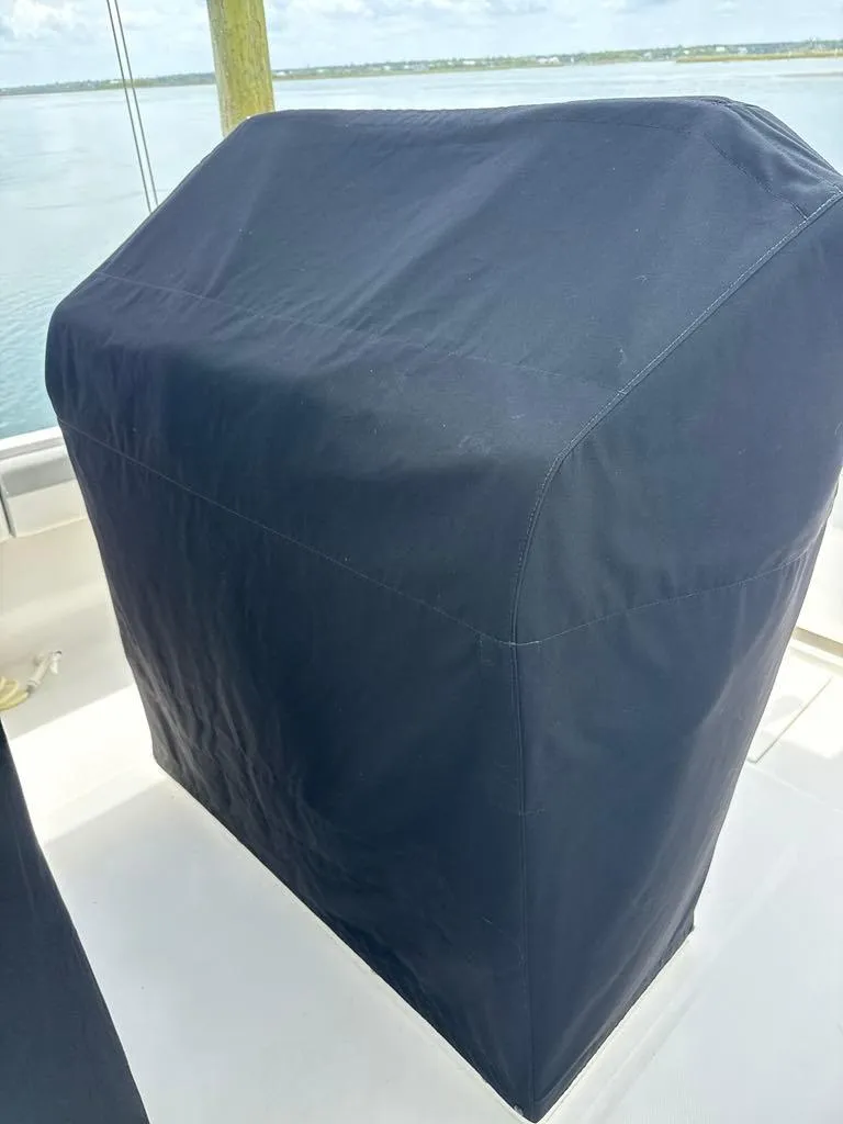 Slide: The Image of 2023 Regulator 28 boat console covered with a protective black cover. - 26