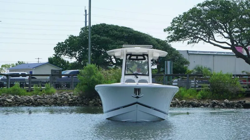 Slide: The Image of 2023 Regulator 28 boat on calm water near shoreline with trees and buildings. - 5