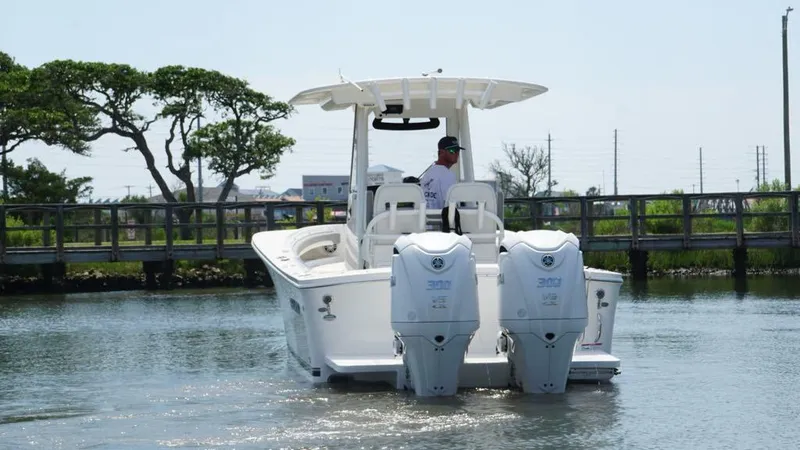 Slide: The Image of 2023 Regulator 28 boat with dual engines on calm water near a wooden dock. - 6
