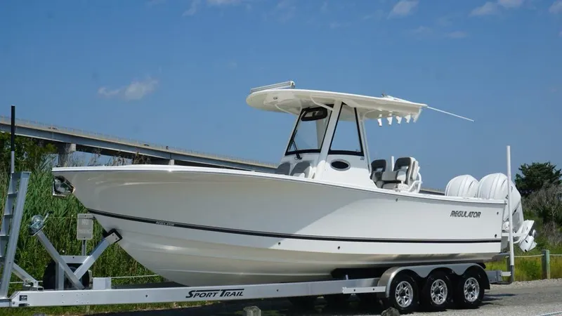 Slide: The Image of 2023 Regulator 28 boat on trailer under clear blue sky. - 8