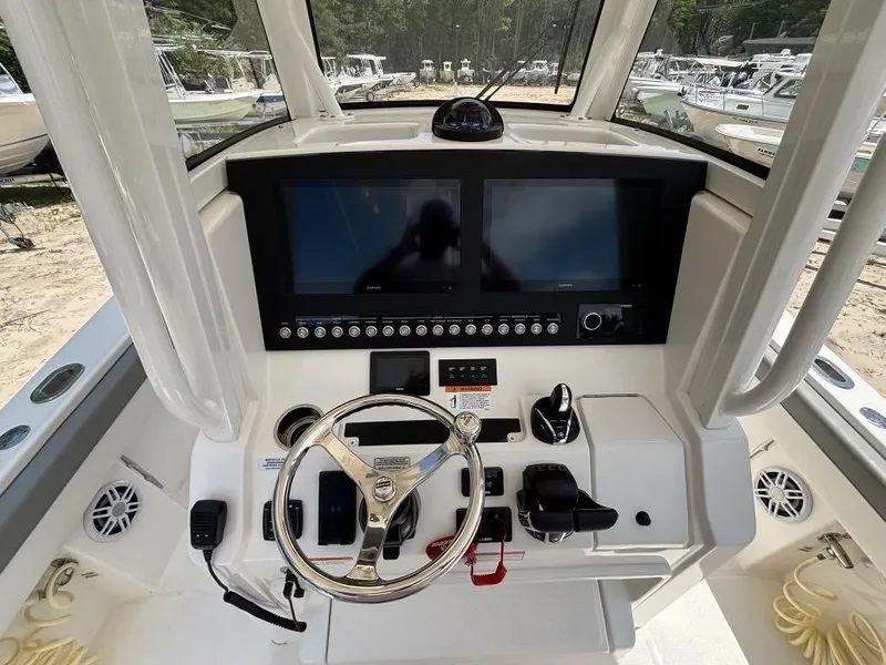 Slide: The Image of 2023 Regulator 28 boat dashboard with dual screens and steering wheel. - 9