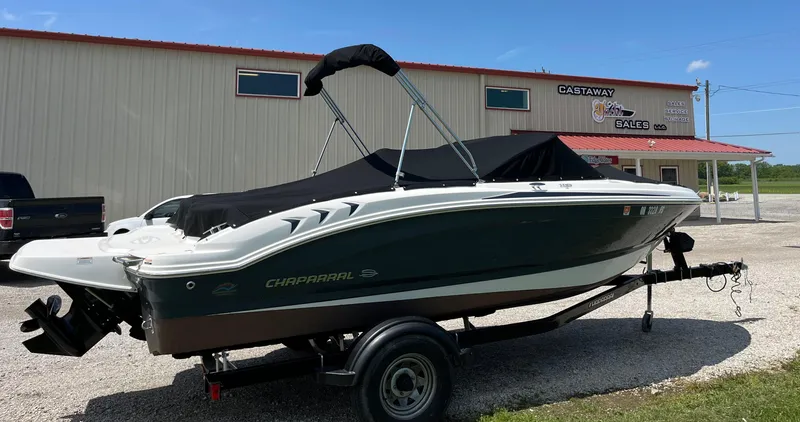 Slide: The Image of 2017 Chaparral 19 H20 Sport boat on trailer, covered, parked outside a building. - 0
