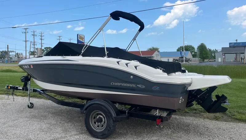 Slide: The Image of 2017 Chaparral 19 H20 Sport boat on trailer, black cover, parked outdoors. - 1