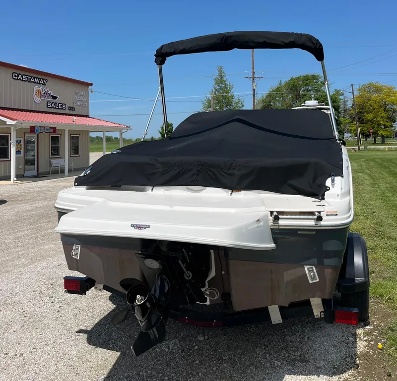 Slide: The Image of 2017 Chaparral 19 H20 Sport boat with cover, parked near a sales building. - 5