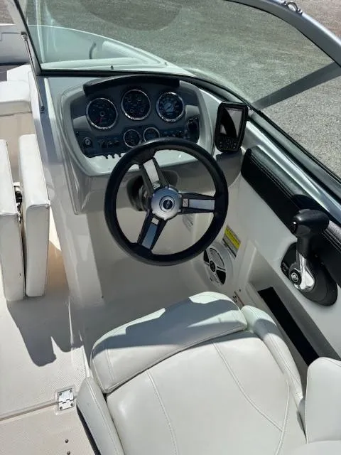 Slide: The Image of 2017 Chaparral 19 H20 Sport boat cockpit with steering wheel and dashboard controls. - 6