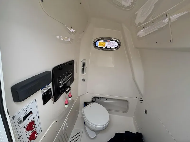 Slide: The Image of Interior of 2019 Boston Whaler 250 Outrage boat, featuring a compact marine toilet. - 13