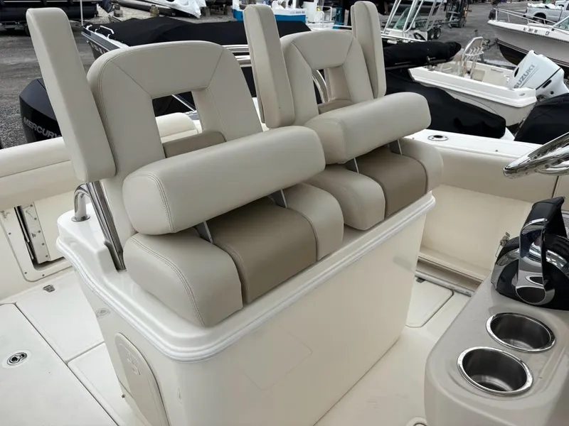 Slide: The Image of 2019 Boston Whaler 250 Outrage boat seats with cup holders, showcasing luxury marine design. - 15