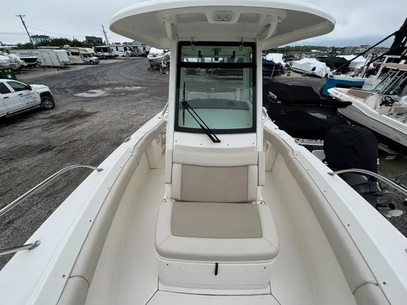 Slide: The Image of 2019 Boston Whaler 250 Outrage boat, front view, in a marina with other boats. - 16