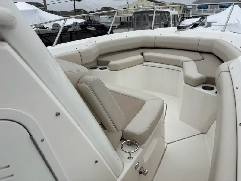 Slide: The Image of 2019 Boston Whaler 250 Outrage boat interior with cushioned seating and cup holders. - 17