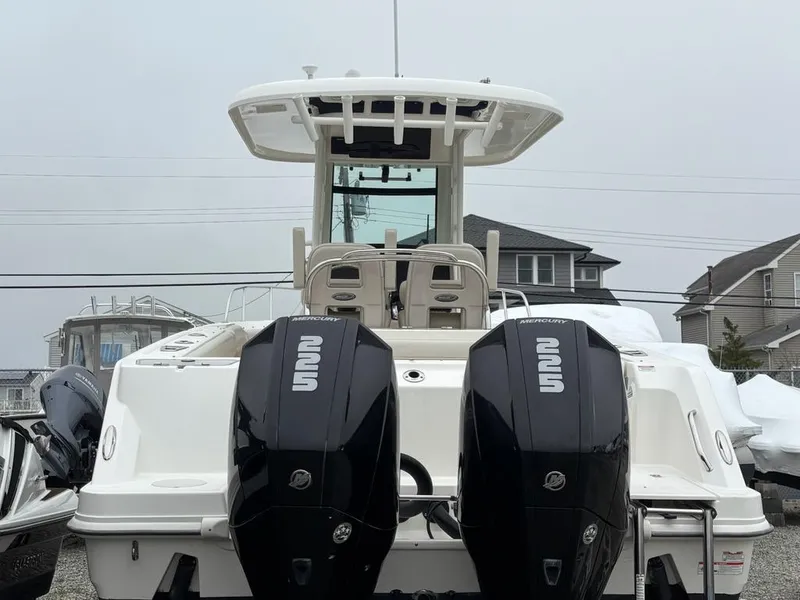 Slide: The Image of 2019 Boston Whaler 250 Outrage with dual outboard engines, docked in a residential area. - 18