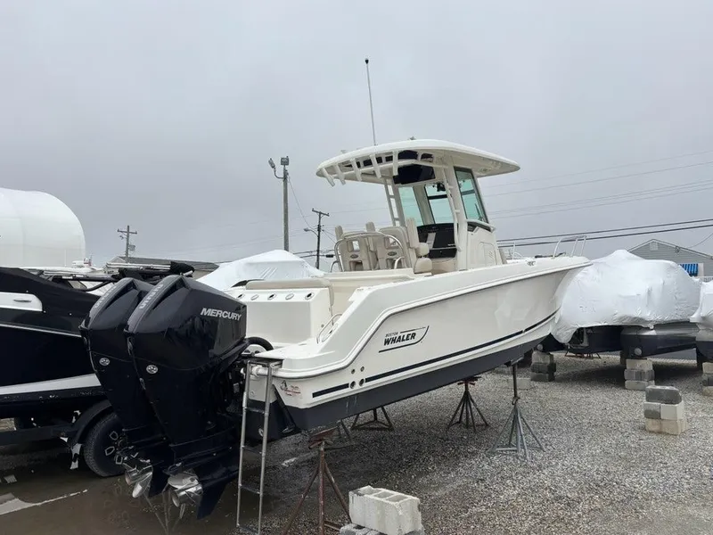 Slide: The Image of 2019 Boston Whaler 250 Outrage boat with dual Mercury engines on a gravel lot. - 3