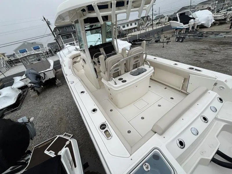 Slide: The Image of 2019 Boston Whaler 250 Outrage boat with spacious deck and seating, docked in a marina. - 4