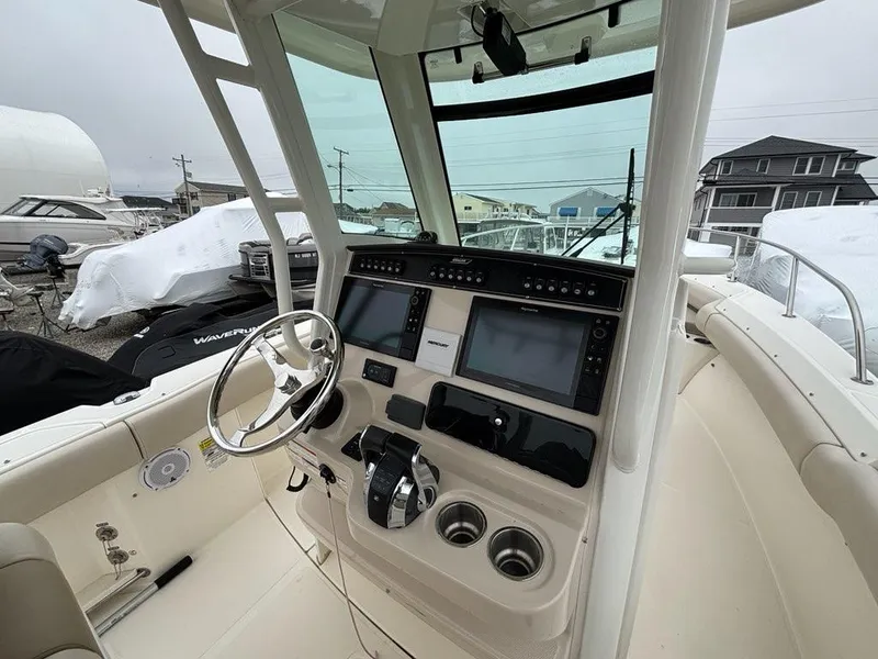 Slide: The Image of 2019 Boston Whaler 250 Outrage boat cockpit with modern navigation equipment and steering wheel. - 7