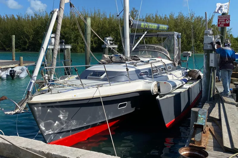 The Image of Sleek 2001 Dragonfly 1200 trimaran docked in a sunny marina. - 0