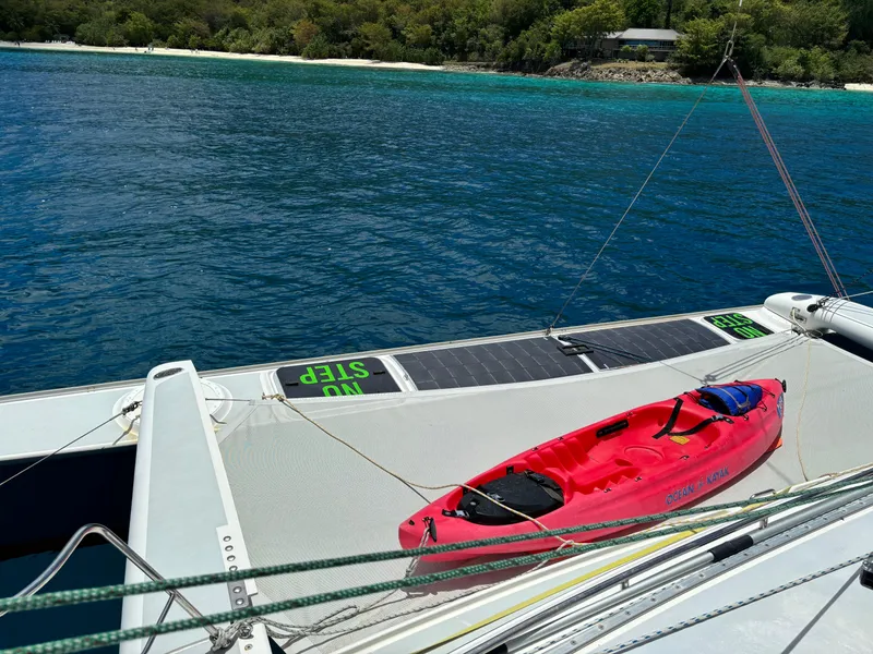 Slide: The Image of Sailboat deck with red kayak, Dragonfly 1200 model, near tropical shoreline. - 10