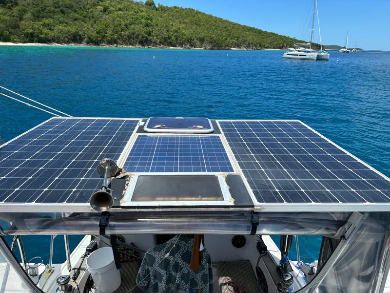 Slide: The Image of Solar panels on a Dragonfly 1200 boat, 2001 model, with ocean and island backdrop. - 13