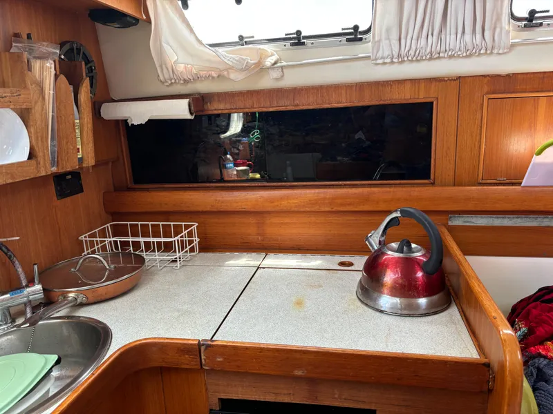 Slide: The Image of Cozy boat kitchen with wooden cabinetry, sink, and red kettle on counter. Dragonfly 1200, 2001. - 17