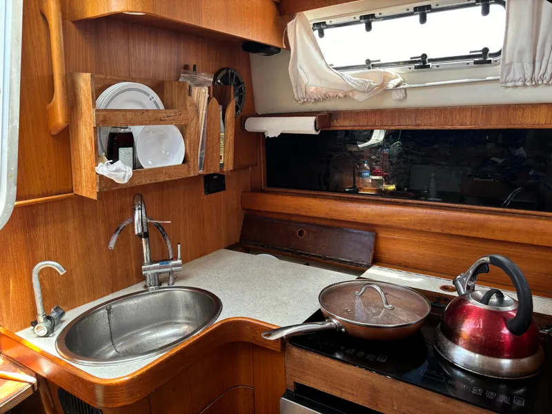 Slide: The Image of Compact boat kitchen with sink, stove, and wooden cabinetry in a 2001 Dragonfly 1200 model. - 18