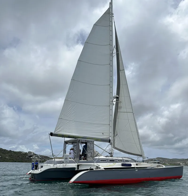 Slide: The Image of Sailing catamaran Dragonfly 1200, 2001 model, on calm waters under cloudy skies. - 2