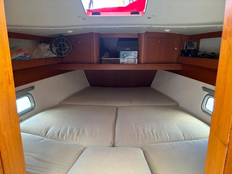 Slide: The Image of Cozy cabin interior of 2001 Dragonfly 1200 sailboat with cushioned bed and wooden storage. - 21