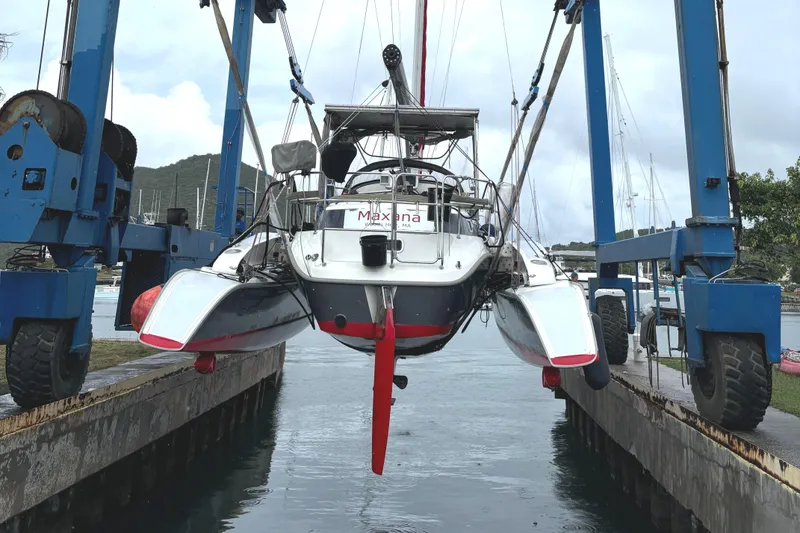 Slide: The Image of Catamaran Dragonfly 1200, 2001 model, lifted by boat hoist in marina setting. - 4