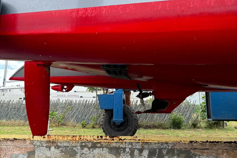 Slide: The Image of Red Dragonfly 1200 boat hull on a trailer, showcasing keel and rudder, 2001 model. - 6