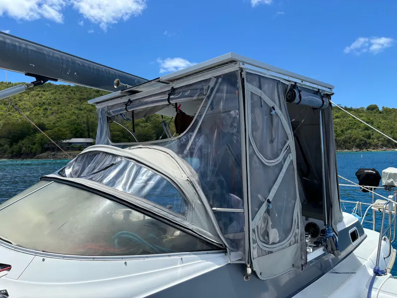 Slide: The Image of Sailboat with protective canopy, Dragonfly 1200, 2001 model, anchored in scenic coastal waters. - 7