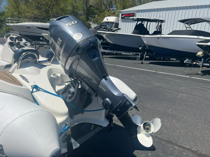 Slide: The Image of Zodiac Yachtline 400 (2019) with outboard motor, parked near other boats in a marina. - 5