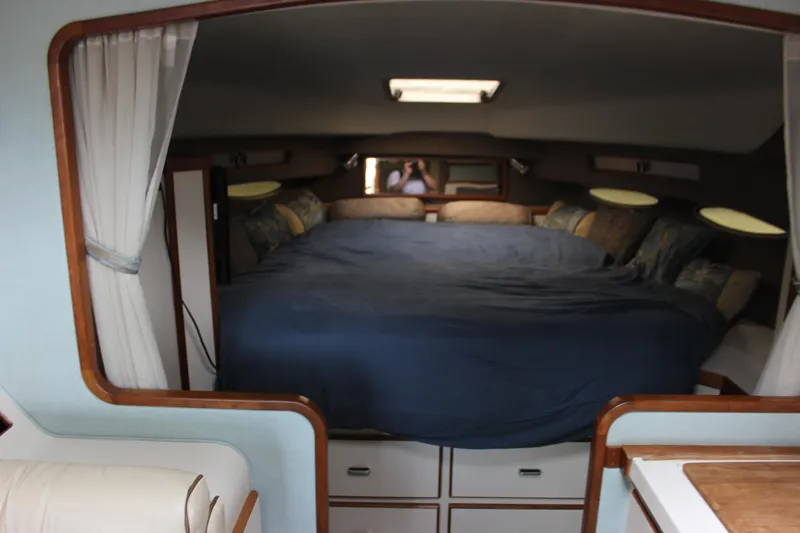 Slide: The Image of 1988 Sea Ray 340 Sundancer cabin interior with bed and storage drawers. - 19