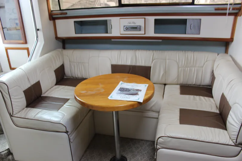 Slide: The Image of 1988 Sea Ray 340 Sundancer interior with beige seating and wooden table. - 20