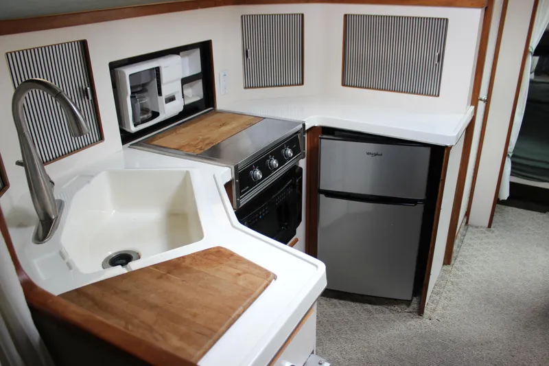 Slide: The Image of 1988 Sea Ray 340 Sundancer kitchen with sink, stove, and refrigerator. - 21