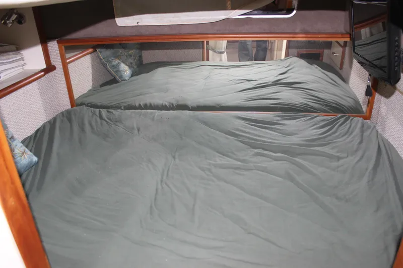 Slide: The Image of 1988 Sea Ray 340 Sundancer cabin with a cozy bed and mirrored wall. - 26