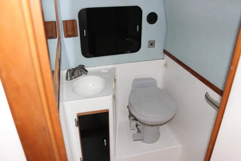 Slide: The Image of 1988 Sea Ray 340 Sundancer bathroom with sink, toilet, and mirror. - 28