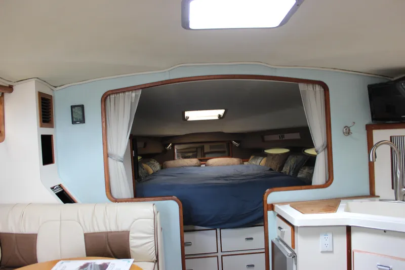 Slide: The Image of Interior of 1988 Sea Ray 340 Sundancer, featuring cozy cabin and kitchenette. - 29