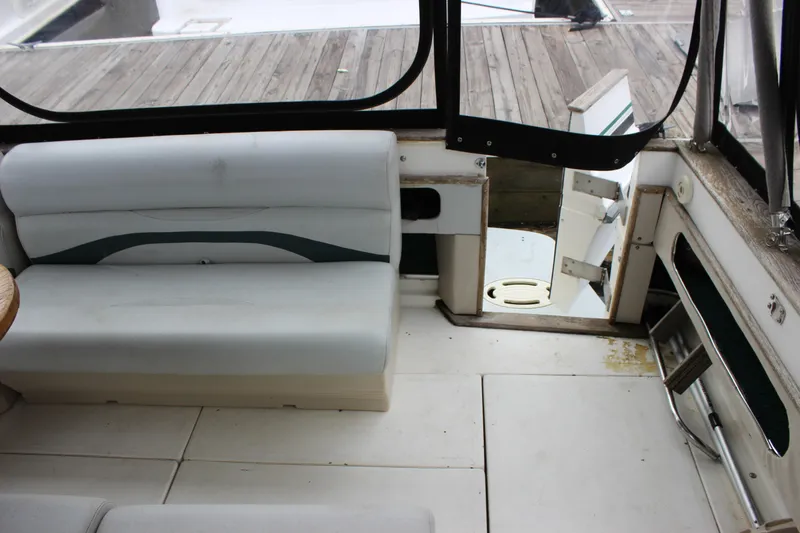 Slide: The Image of 1988 Sea Ray 340 Sundancer interior with white seating and open cabin door. - 32