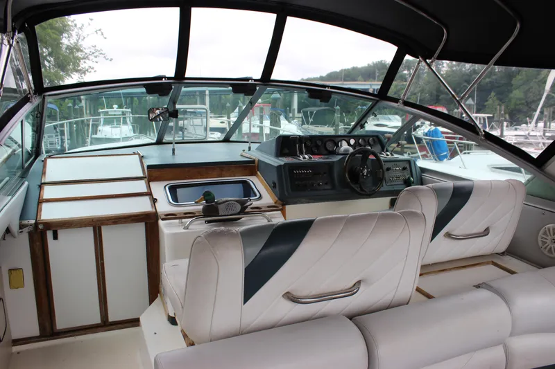 Slide: The Image of 1988 Sea Ray 340 Sundancer cockpit with steering wheel, dashboard, and seating. - 33