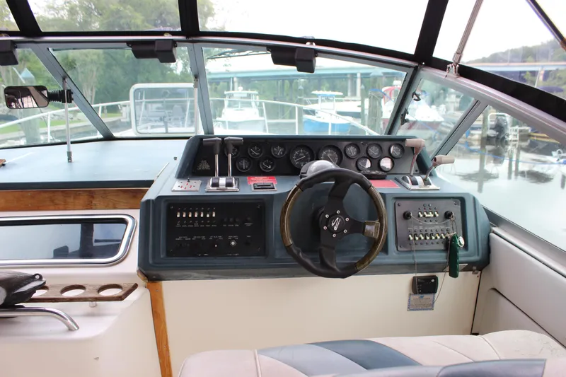 Slide: The Image of Cockpit of 1988 Sea Ray 340 Sundancer with steering wheel and control panel. - 34