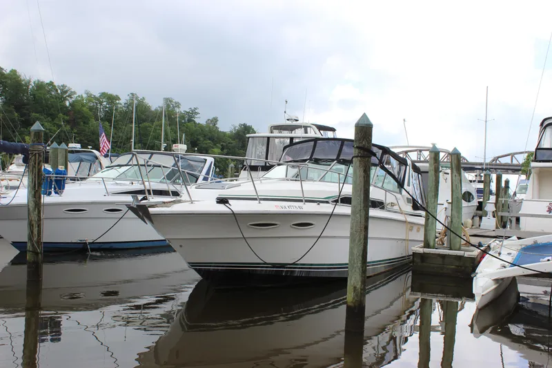 Slide: The Image of 1988 Sea Ray 340 Sundancer docked at marina, surrounded by other boats. - 38