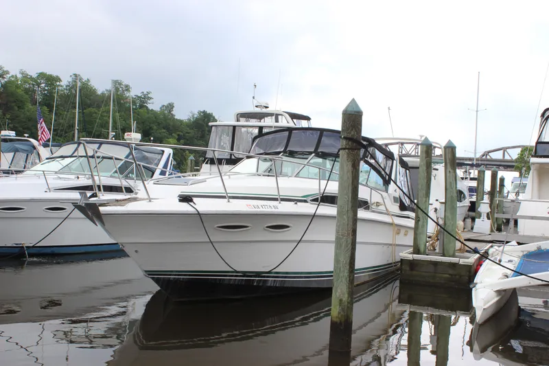 Slide: The Image of 1988 Sea Ray 340 Sundancer docked at a marina, surrounded by other boats. - 39