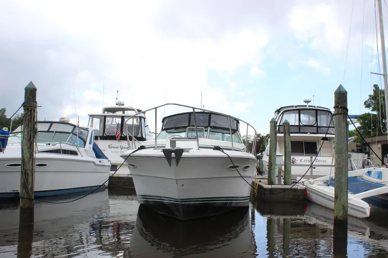 Slide: The Image of 1988 Sea Ray 340 Sundancer docked among other boats in a marina. - 40