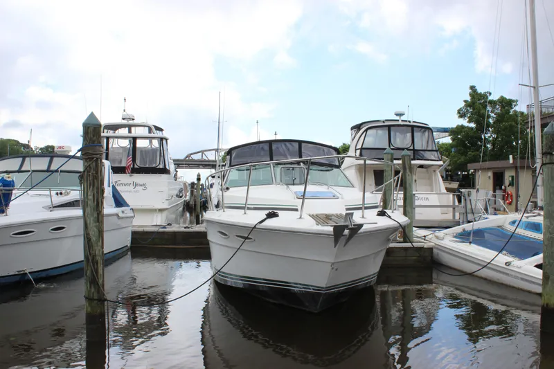 Slide: The Image of 1988 Sea Ray 340 Sundancer docked among other boats in a marina. - 41