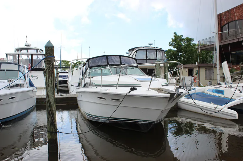 Slide: The Image of 1988 Sea Ray 340 Sundancer docked at marina, surrounded by other boats. - 42