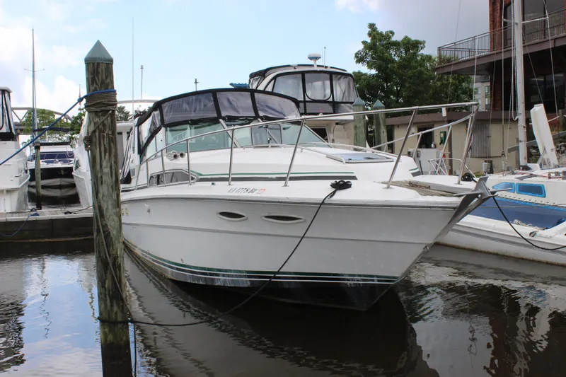 Slide: The Image of 1988 Sea Ray 340 Sundancer docked at marina, featuring sleek white design and spacious deck. - 43