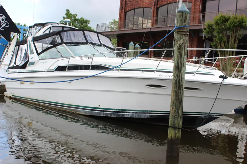 Slide: The Image of 1988 Sea Ray 340 Sundancer docked at marina, featuring sleek design and spacious cabin. - 44
