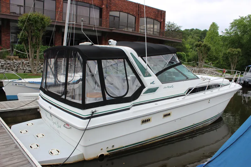 Slide: The Image of 1988 Sea Ray 340 Sundancer boat docked near a brick building. - 5