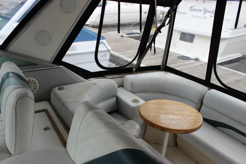 Slide: The Image of Interior of 1988 Sea Ray 340 Sundancer with white seating and wooden table. - 9