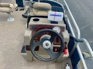 Slide: The Image of 2023 Sun Tracker Bass Buggy 16 XL steering console with Lowrance device and beige seating. - 3