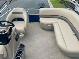 Slide: The Image of 2023 Sun Tracker Bass Buggy 16 XL pontoon boat interior with beige seating and steering console. - 4