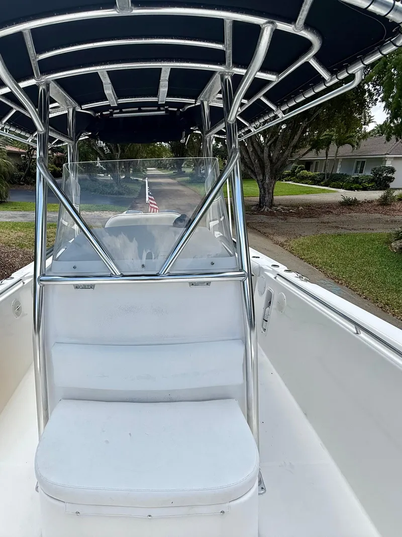 Slide: The Image of 2006 Edgewater 265CC boat with T-top and seating, parked outdoors. - 12