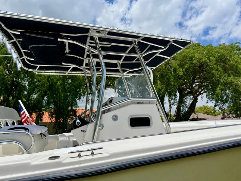 Slide: The Image of 2006 Edgewater 265CC boat with T-top, parked outdoors under a cloudy sky. - 8